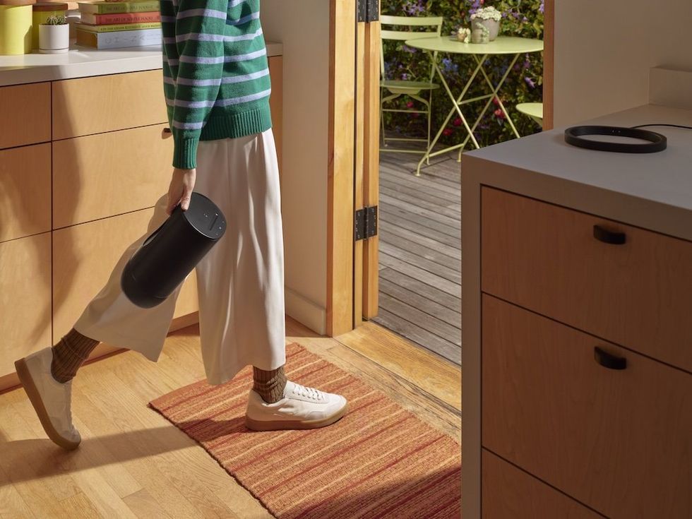 a woman carrying a sonos move 2 speaker