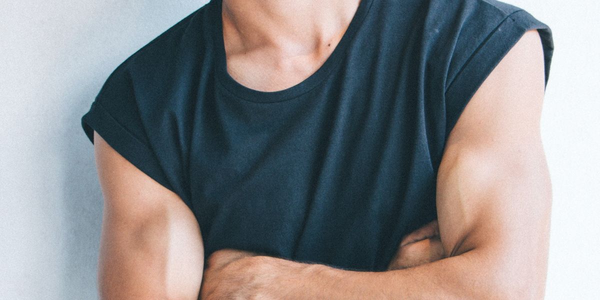 Man in a sleeveless shirt with his arms crossed.