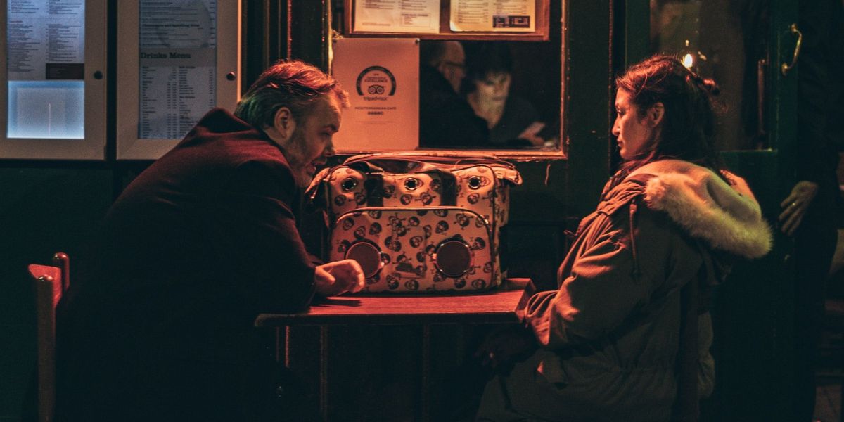 man and woman sitting in front of each other at night