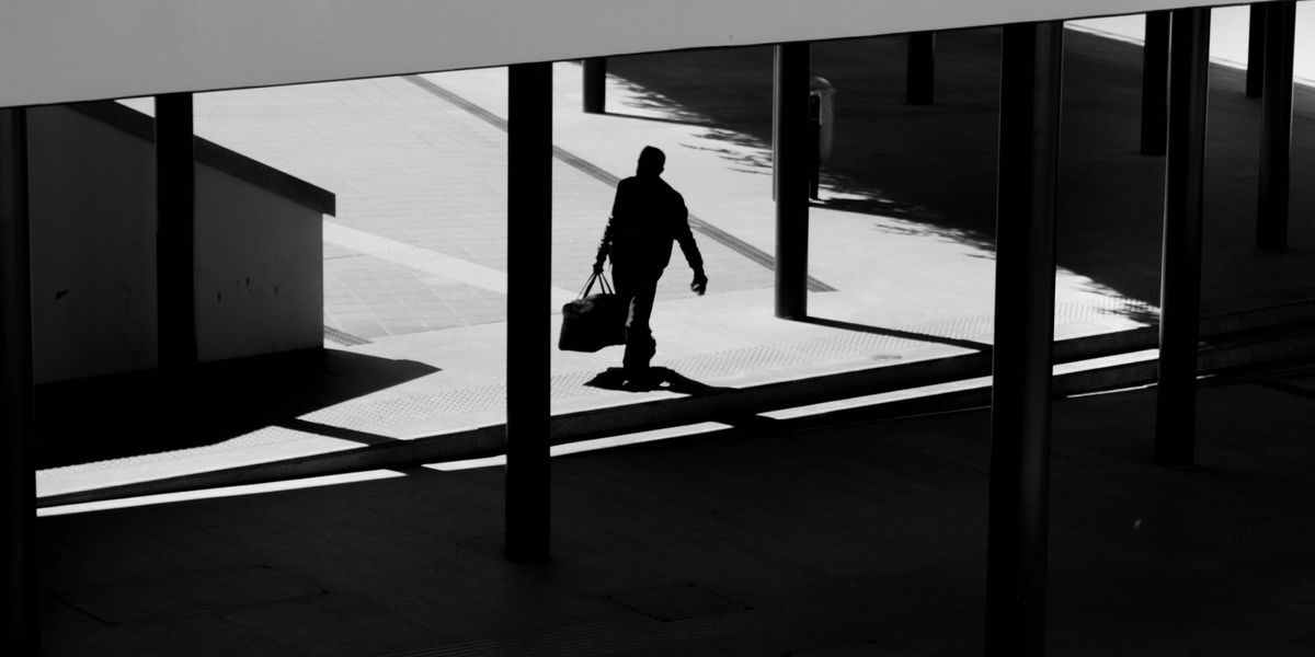 Silhouette of man leaving an office carrying a briefcase