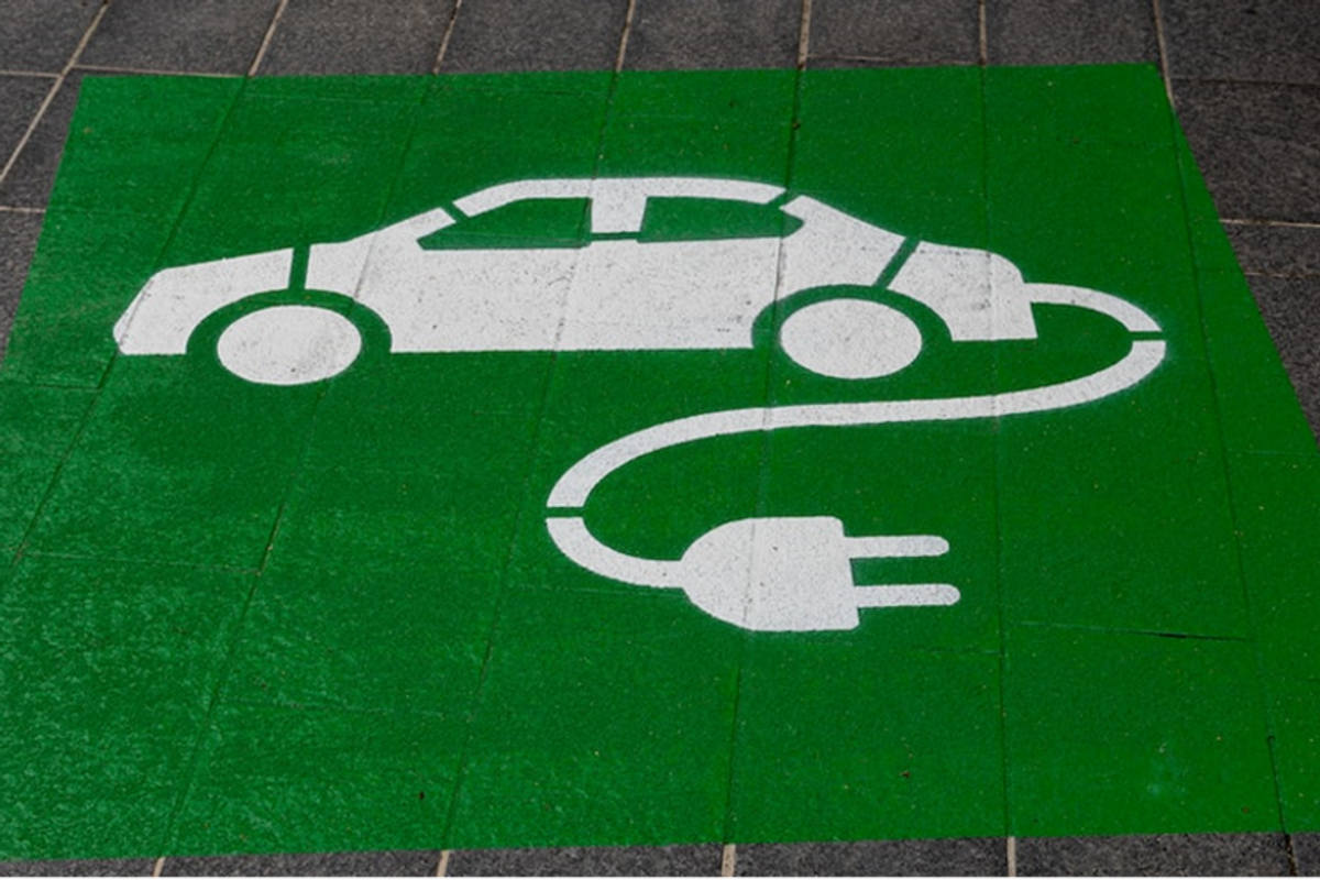 an imagre of a doormat with an illustration of an electric car and power cord.