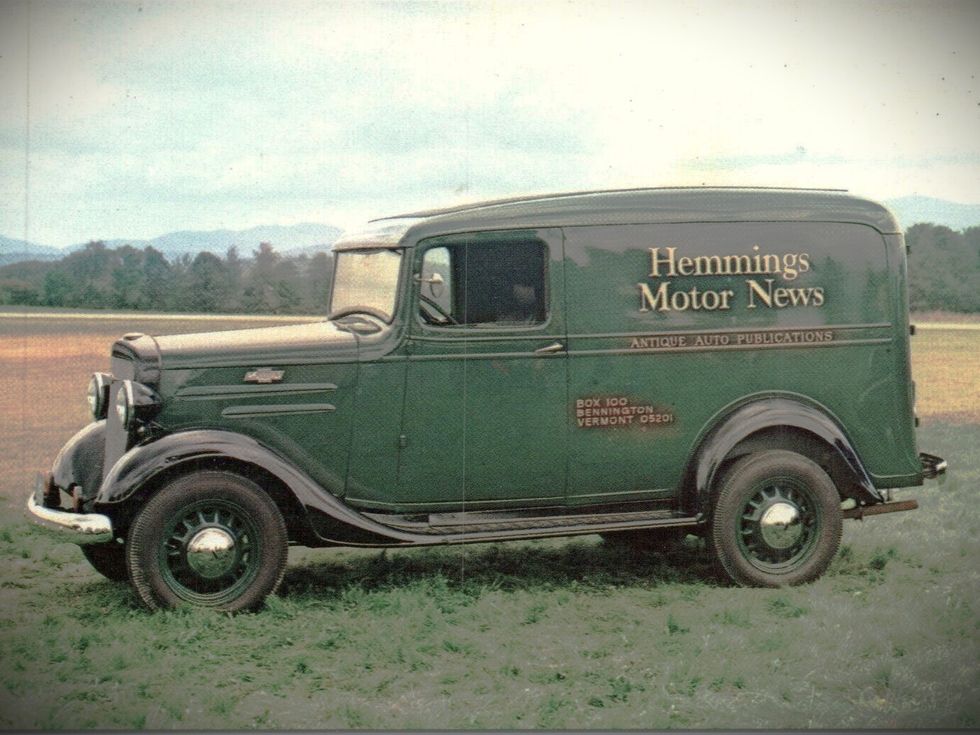 A green 1936 Chevrolet panel truck in a field. On the side is painted "Hemmings Motor News: Antique Auto Publications."