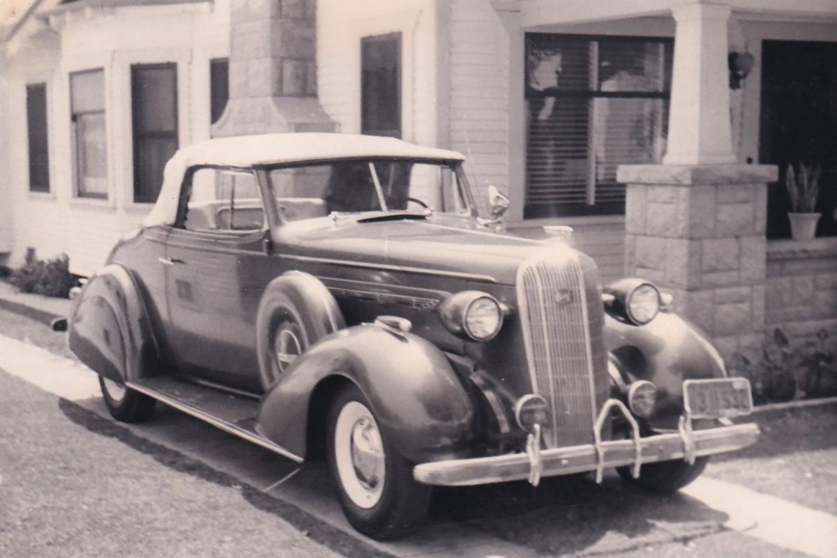 B&W image of a 1936 Buick Special parked next to a house, period image.