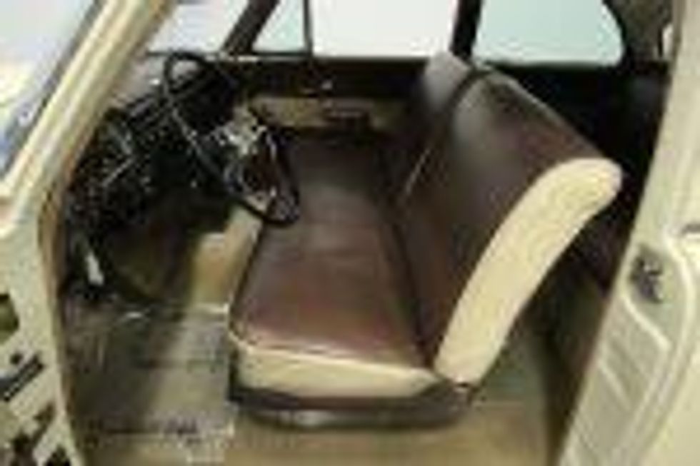 Bench seat of a 1953 Ford upholstered in a brown and cream.