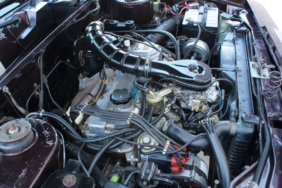 Color closeup image of the engine bay in a 1982 Chrysler LeBaron Medallion Mark Cross edition.