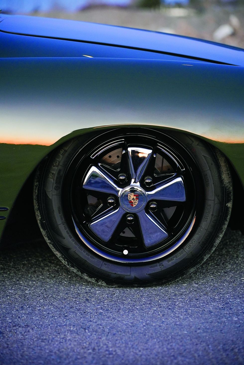 Color closeup of Porsche Fuchs wheels on a customized 1965 Volkswagen Karmann Ghia.