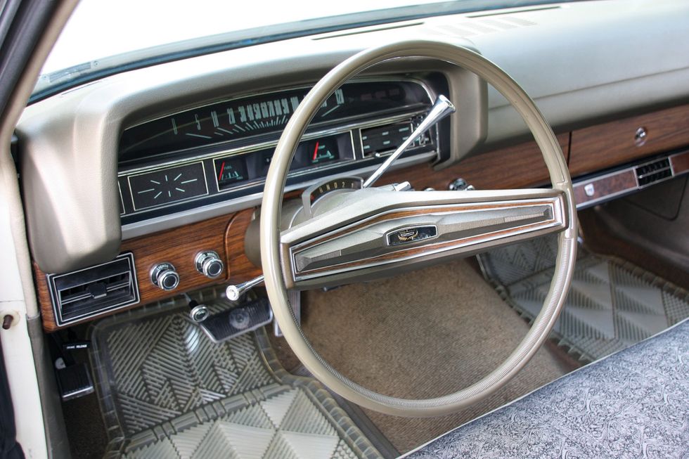Farbige Nahaufnahme des Armaturenbretts, des Lenkrads und des Kombiinstruments in einem Ford Torino Brougham von 1971.