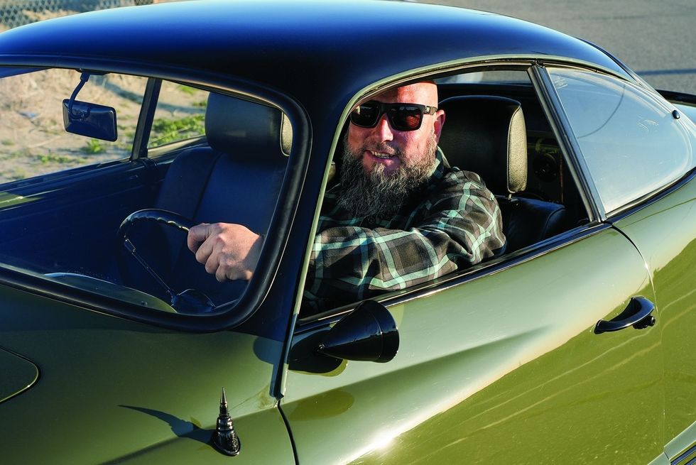 Color closeup of the owner at the wheel in his customized 1965 Volkswagen Karmann Ghia.
