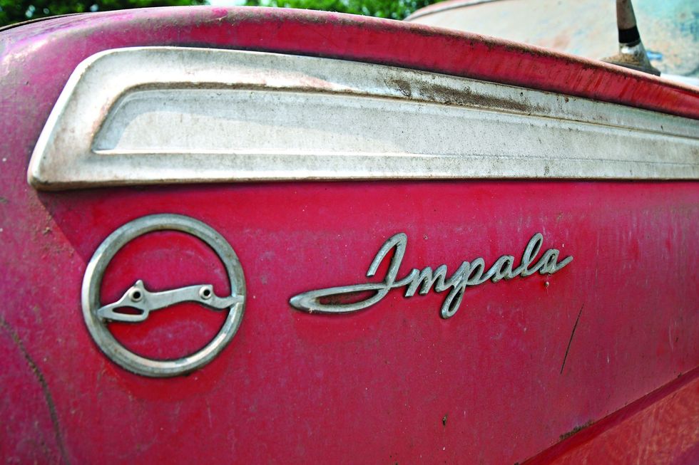 Color closeup of the quarter panel emblem on a 1962 Chevrolet Impala barn find.