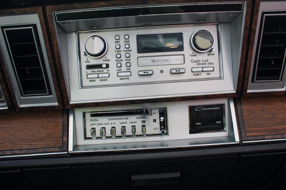 Color closeup of the radio and climate controls in a 1982 Chrysler LeBaron Medallion Mark Cross edition.