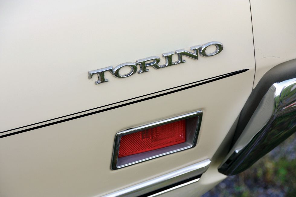 Farbige Nahaufnahme der hinteren Seitenmarkierung und des Torino-Schriftzugs an einem 1971er Ford Torino Brougham.