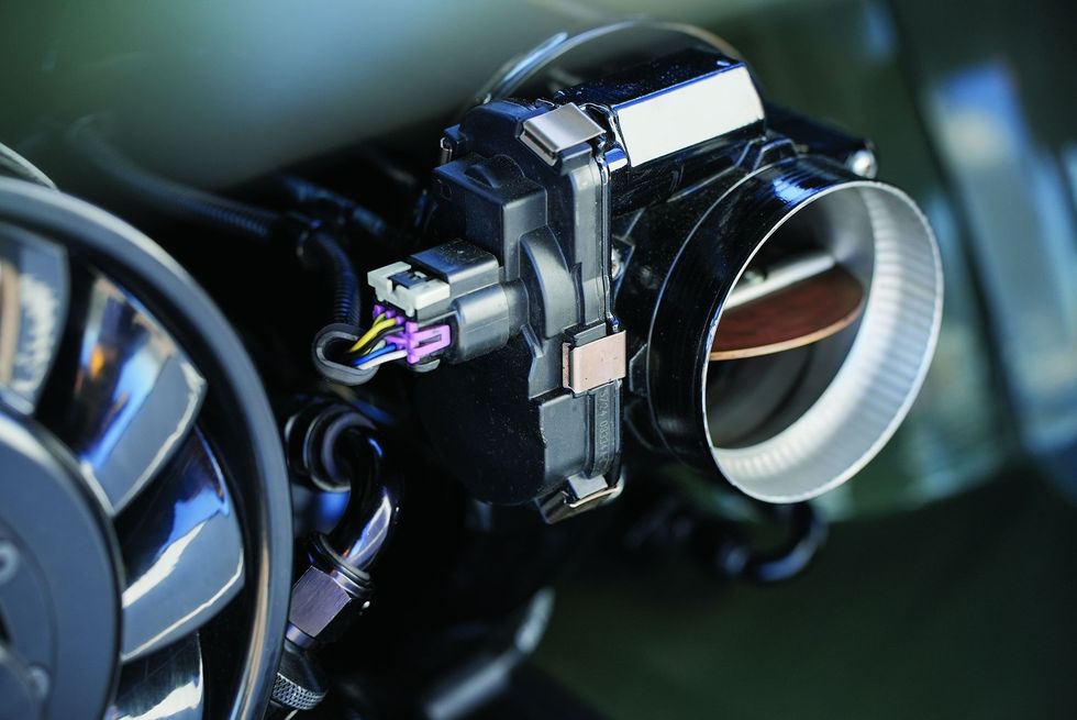 Color closeup of throttle body on a carb in a customized 1965 Volkswagen Karmann Ghia.