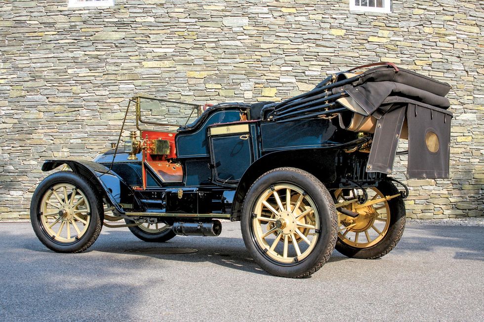 Farbbild eines Knox Model R Touring von 1910, der vor einem Gebäude geparkt ist, hinten in 3/4-Position.