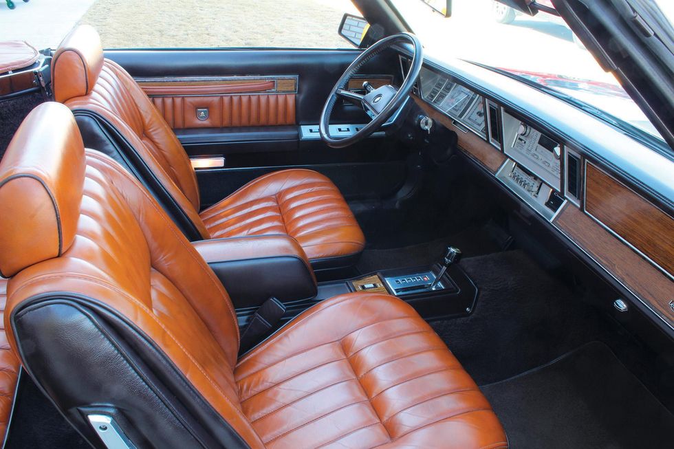 Color image of the dash, steering wheel, seats, door panel, floor and interior of a 1982 Chrysler LeBaron Medallion Mark Cross Edition.