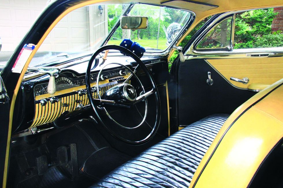 Color image of the interior, dash, steering wheel, door panel, seats and more in a 1950 Mercury Monterey Sport Coupe.