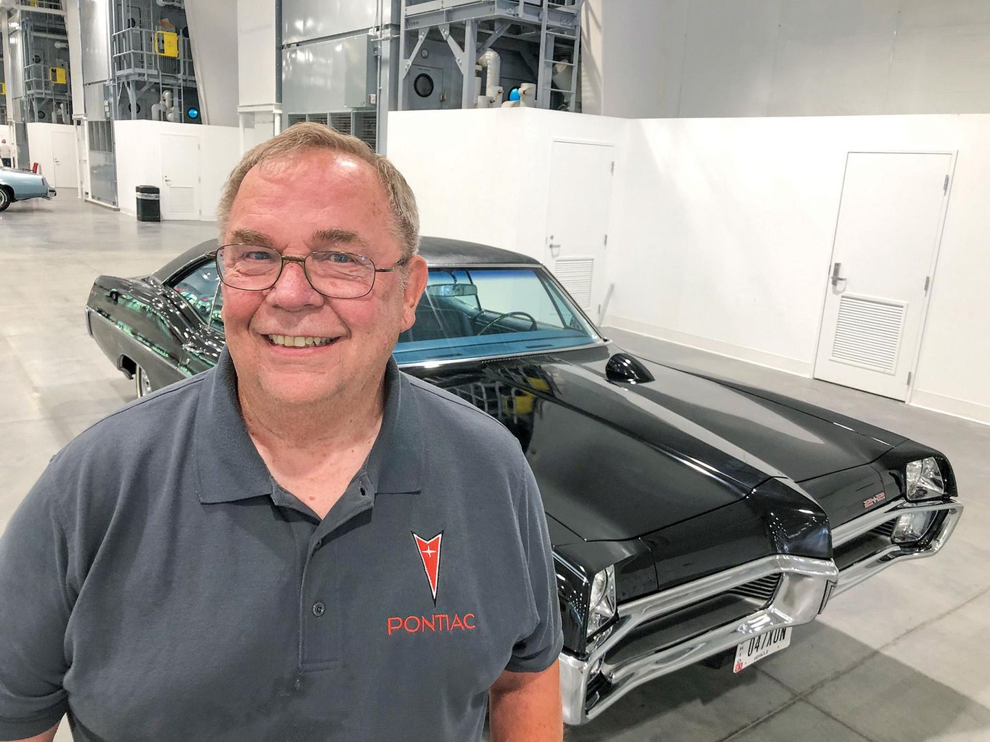 Color image of the owner of his 1967 Pontiac Catalina 2+2 posing in front of the car