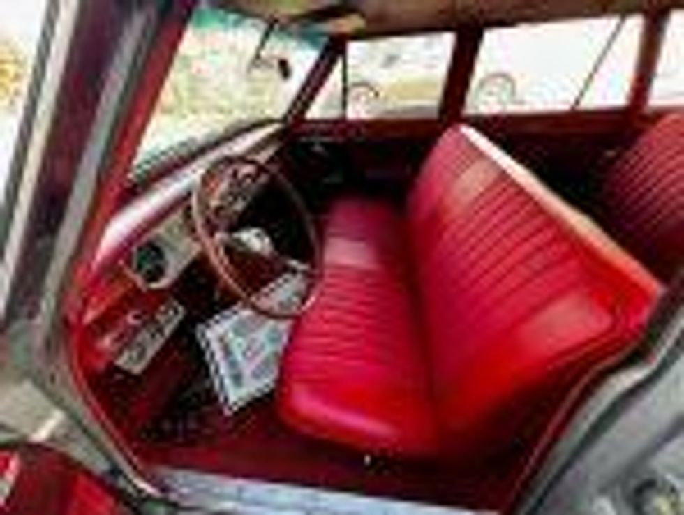 The front seat of the red interior of a 1962 Chevrolet Chevy II station wagon.